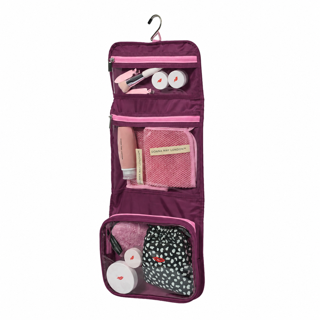 Purple hanging travel organizer with pink accents containing various toiletries on a white background