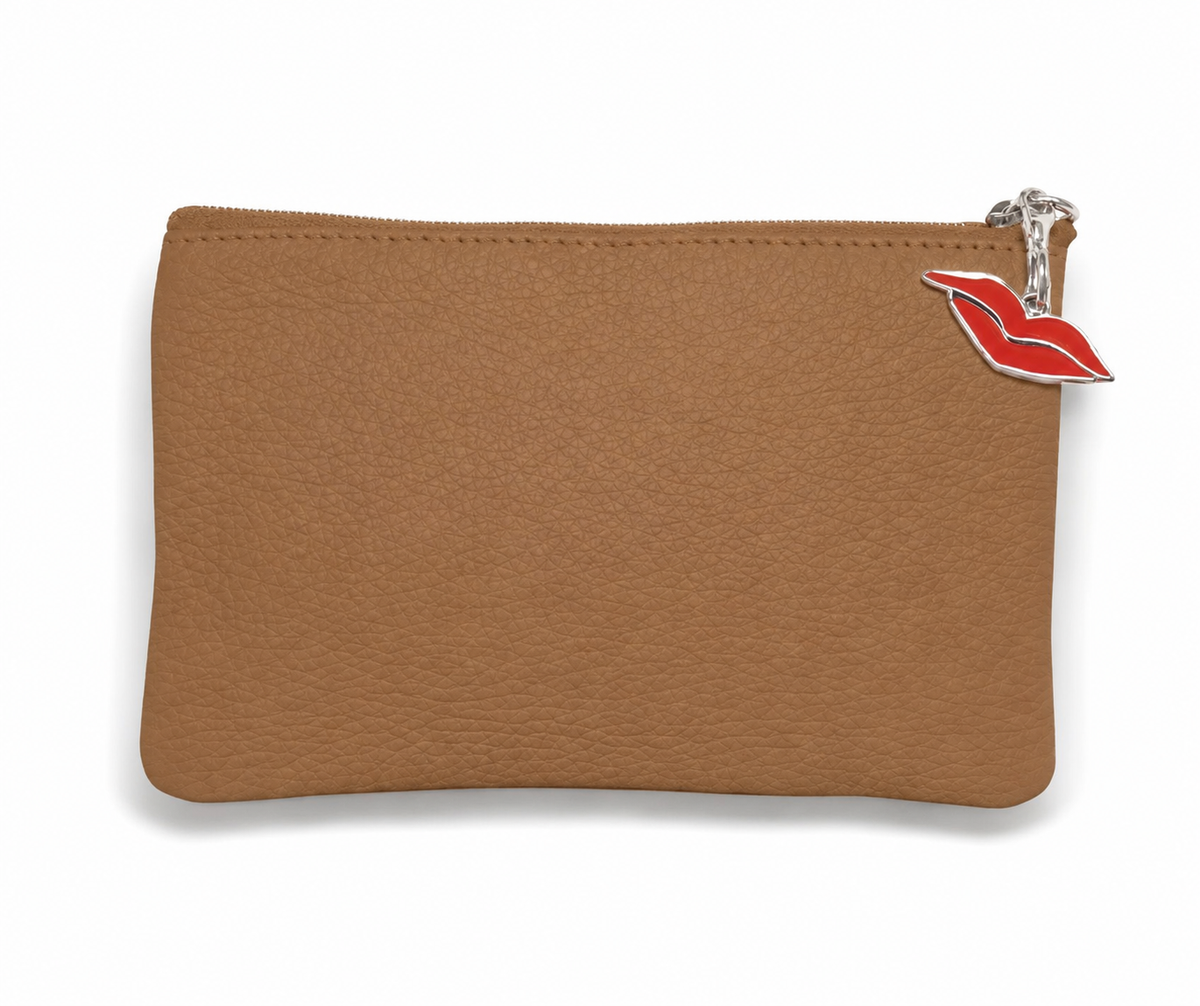 A tan leather purse with a silver metal zipper and a red lip charm.
