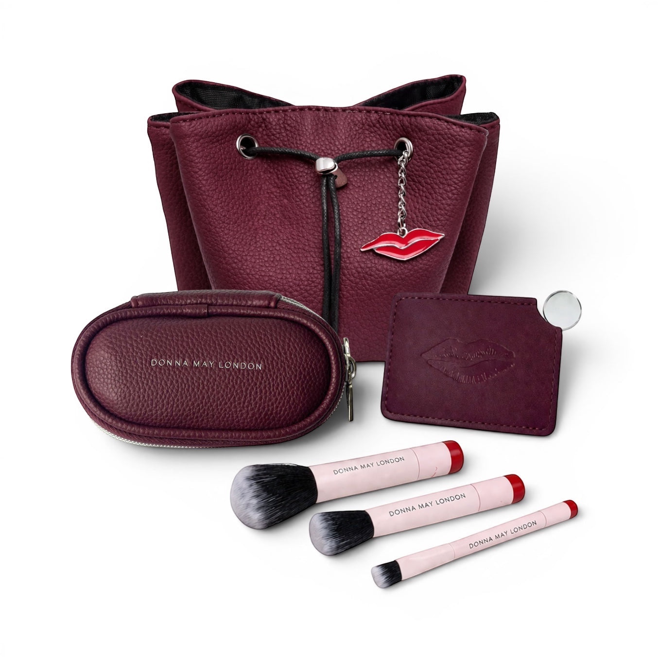 Donna May London burgundy leather handbag bundle with makeup bag, brush set, and mirror. Features our iconic lip charm.