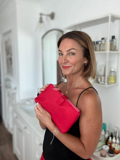 Donna May holding a red pouch in a bathroom setting